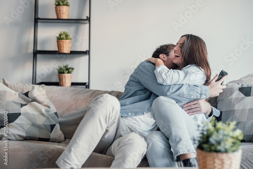 Excited millennial husband and wife relax on couch in kitchen feel euphoric win lottery online on cellphone, overjoyed young couple triumph celebrate read good unexpected news on smartphone gadget.
