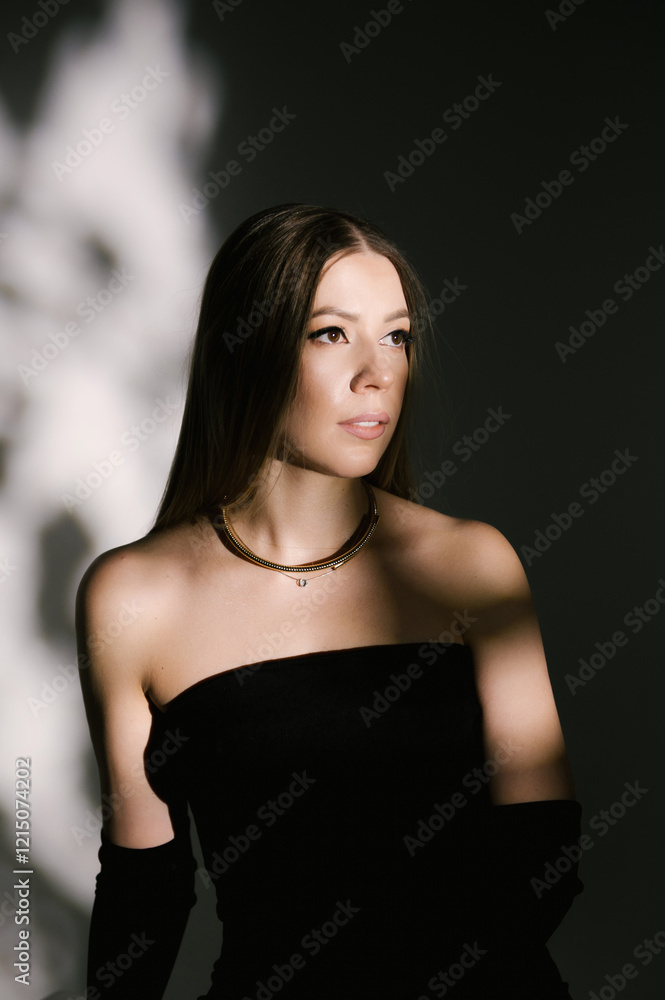Portrait of a woman in a studio with professional lighting in a smart dress with gloves