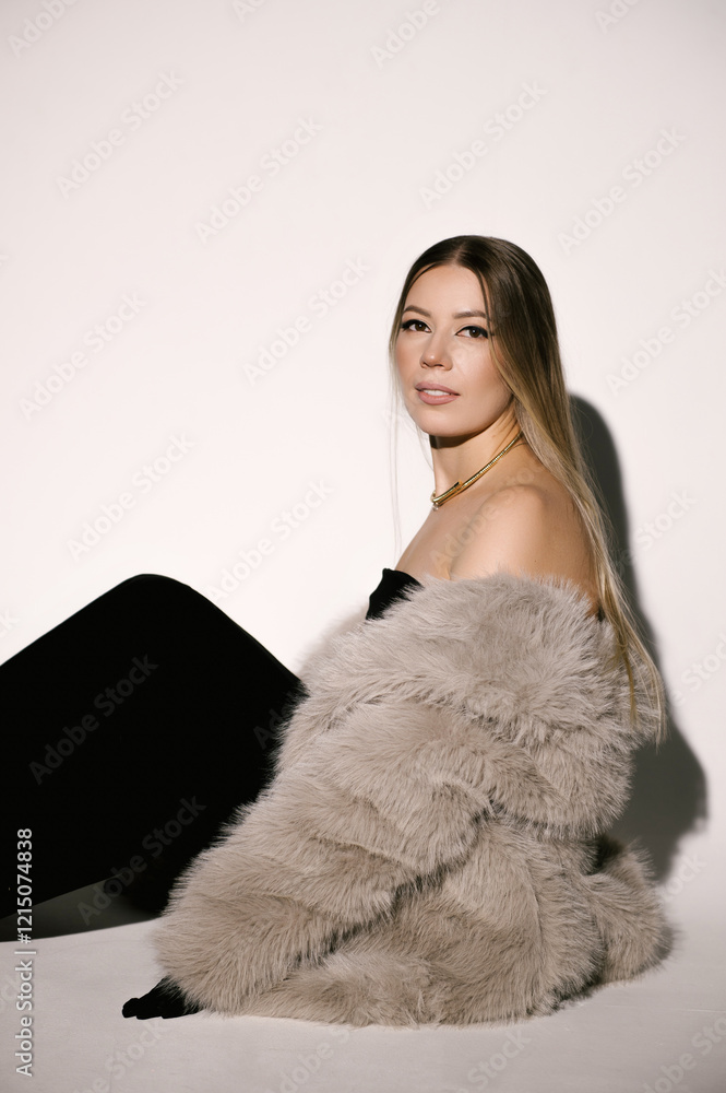 Portrait of a woman in a studio with professional lighting in a smart dress with gloves and a fur coat