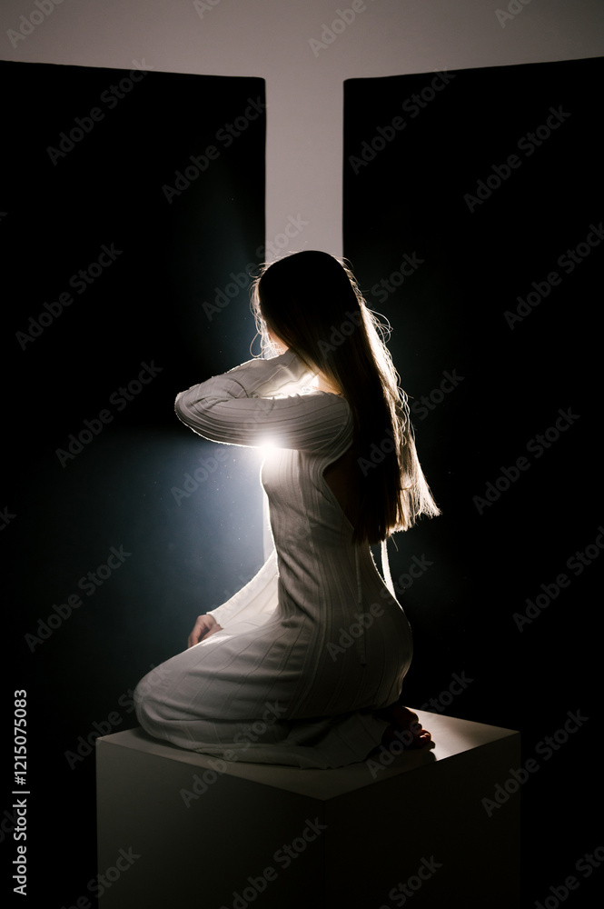 Portrait of a woman in a studio with professional lighting in a white long dress, soft focus