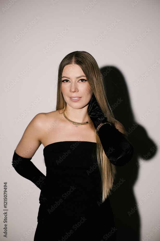 Portrait of a woman in a studio with professional lighting in a smart dress with gloves