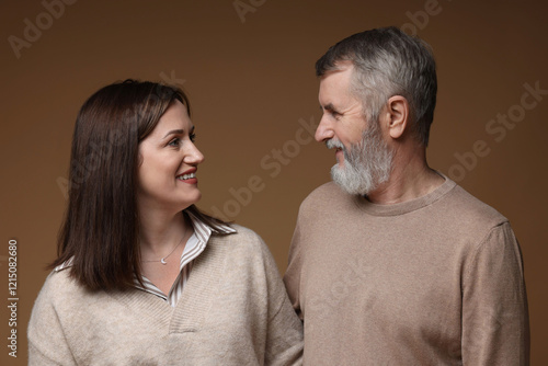 Quadro su tela Happy daughter and her father looking at each other on brown background