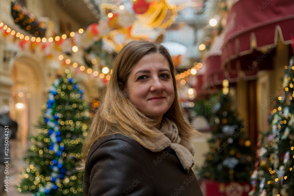 Smiling woman enjoys festive atmosphere in a beautifully decorated shopping arcade during the holiday season Smiling woman enjoys festive atmosphere in a beautifully decorated shopping arcade during the holiday season