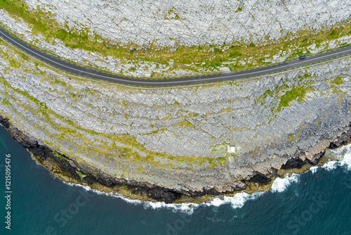 Black Head Lighthouse, situated in the rough rocky landscape of Burren, amidst a bizarre scenery of limestone mountains and rocky coastline, County Clare, Ireland. photo