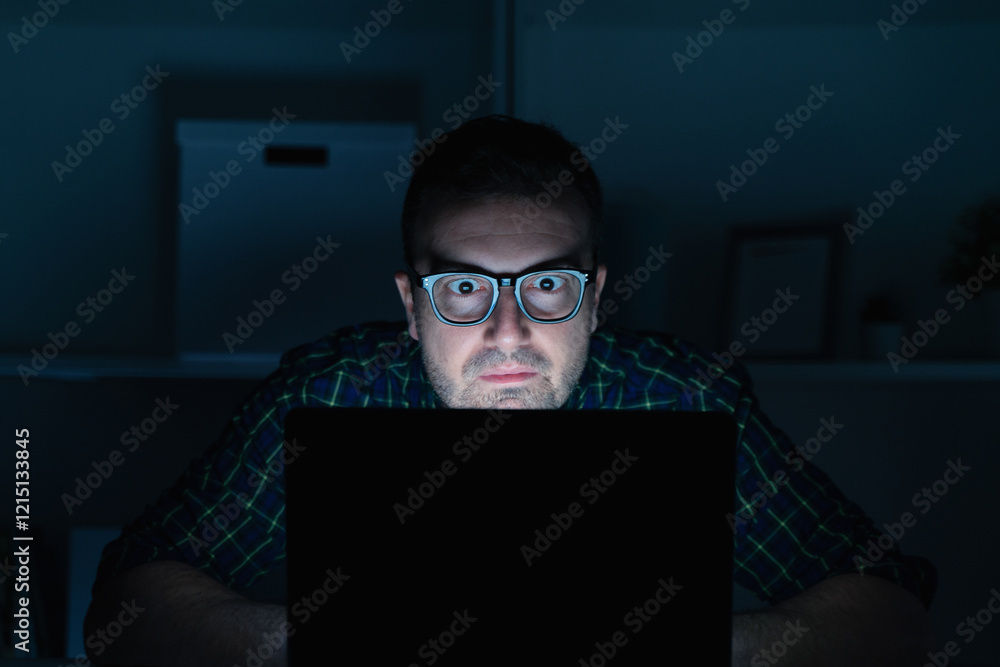 One geek guy using laptop at night One geek guy using laptop at night