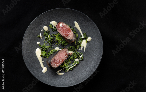 This gourmet dish features grilled meat on fresh spinach with a rich, flavorful sauce. Top view