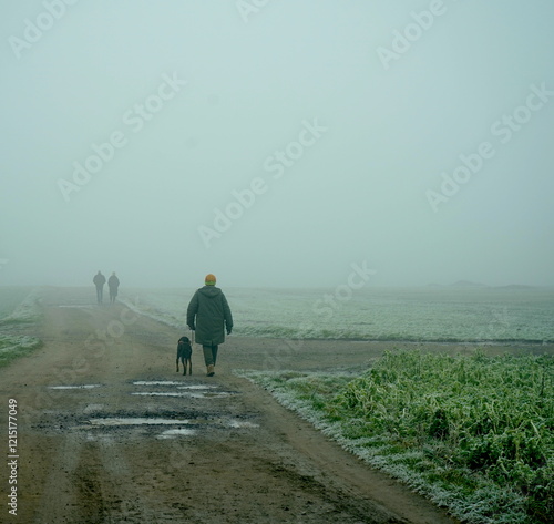 Spaziergänger mit Hund im Nebel photo