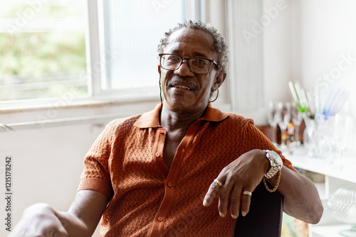 Fotografie Black elegant senior man, drinking brazilian  beer and listening samba, Brazilian traditional music in to vinyl player in his Brazilian home