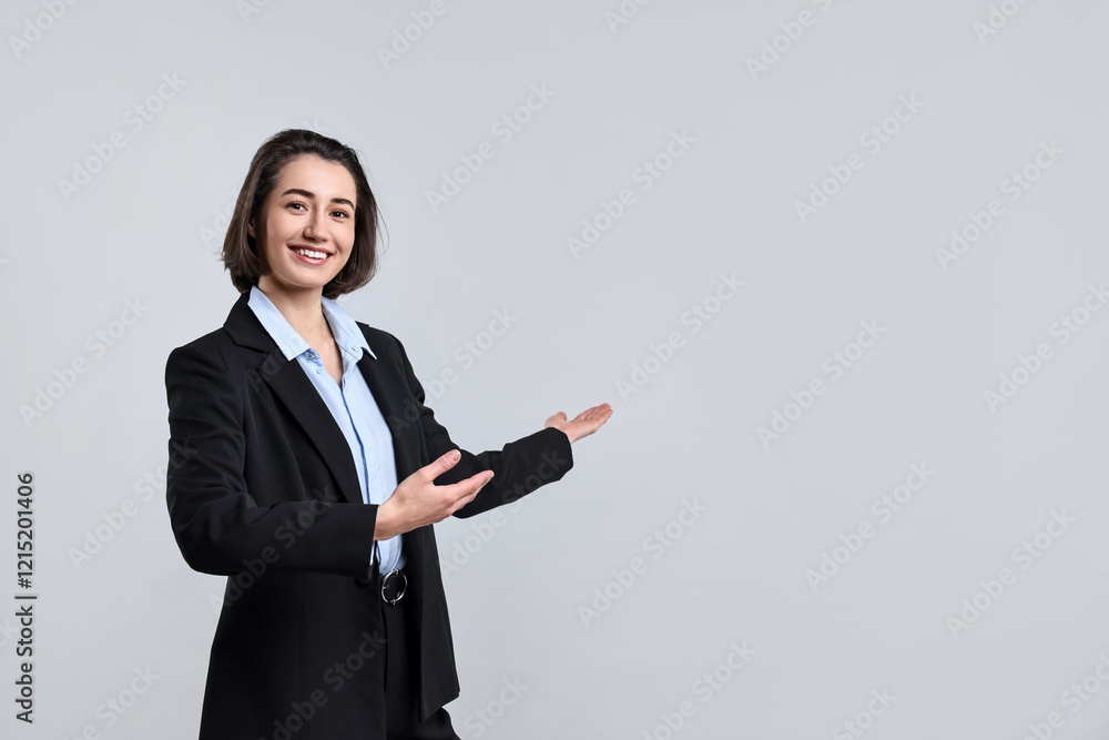 Happy businesswoman welcoming clients or partners on light grey background Happy businesswoman welcoming clients or partners on light grey background