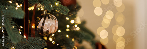 Tableau sur toile Christmas tree with golden decoration and lights garland close-up with copy space
