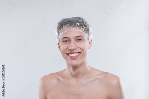 Man in shower cap on light grey background photo