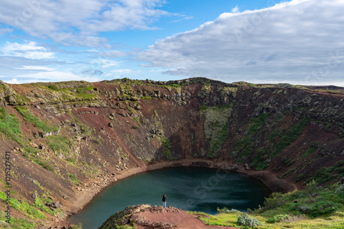 Lone female tourist admiring Kerid Crater, Grimsnes area, Southern Iceland photo