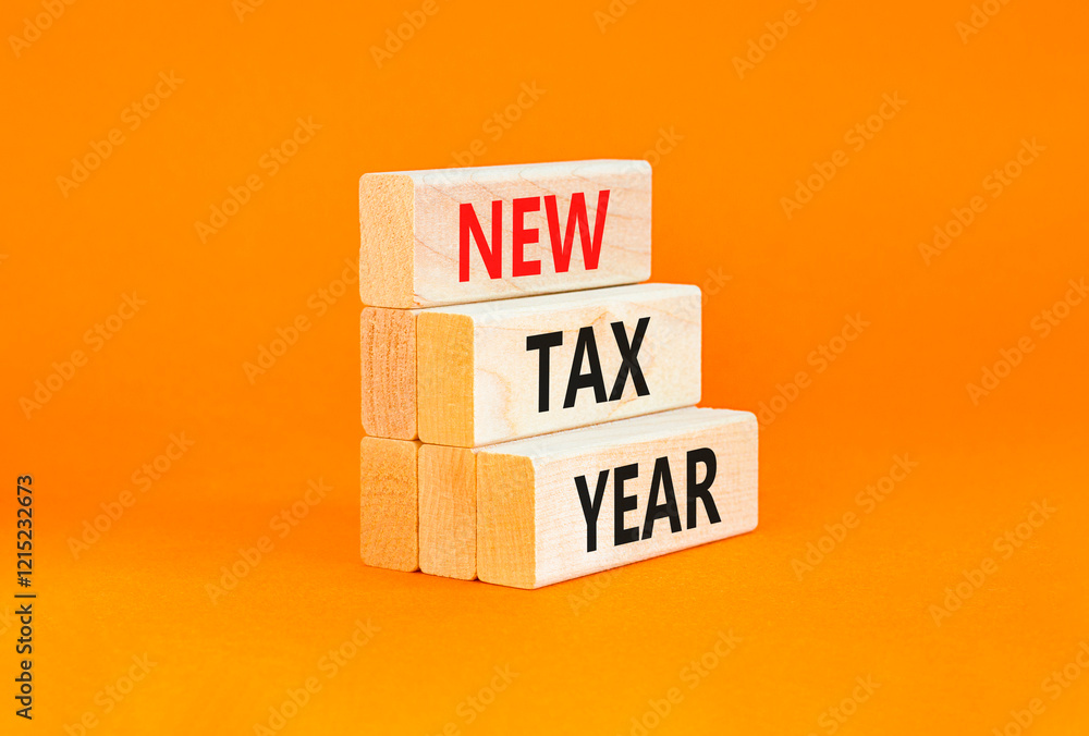 Naklejka premium New tax year symbol. Concept words New tax year on beautiful wooden blocks. Beautiful orange table orange background. Business new tax year concept. Copy space.