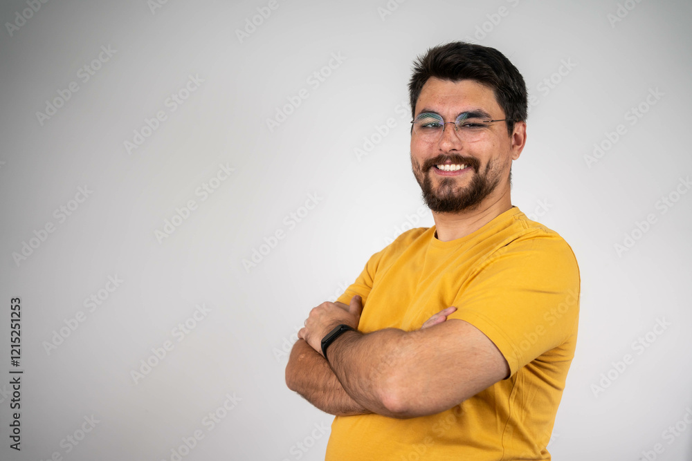 Portrait of handsome smiling young man with folded arms. Smiling joyful cheerful men with crossed hands studio shot. Isolated on gray background Portrait of handsome smiling young man with folded arms. Smiling joyful cheerful men with crossed hands studio shot. Isolated on gray background