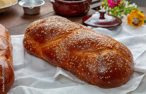 Easter sweet bread, two tsoureki braids on white table cloth, closeup photo