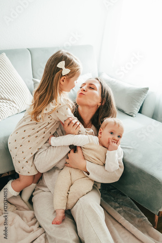 Happy mother and little children in cozy home. Family relationships. Mother's Day.
