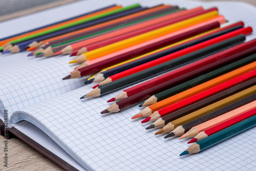 Colored pencils and a notebook Colored pencils and a notebook