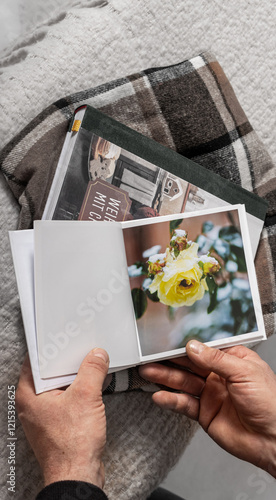 Männerhände halten ein offenes Buch, Leere Buchseite,
Buchseite mit Rose, Winterrose im Schnee, Buch ansehen  photo