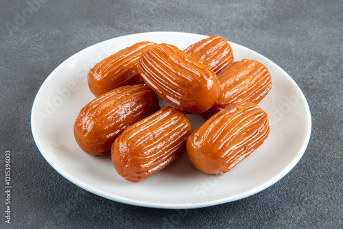 Traditional Turkish dessert tulumba on a plate. Tulumba dessert, fried in oil and soaked in syrup