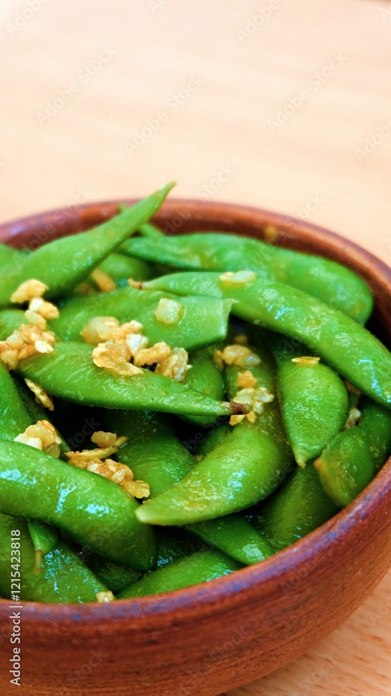 A bowl of edamame, japanese beans associated with healthy food and lifestyle, seasoned with garlic butter sauce A bowl of edamame, japanese beans associated with healthy food and lifestyle, seasoned with garlic butter sauce