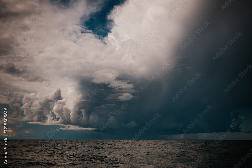 Obraz premium The dark sky with heavy clouds converging and a violent storm before the rain.Bad or moody weather sky and environment. carbon dioxide emissions, greenhouse effect, global warming, climate change.