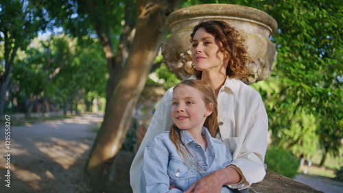 Foto Loving mom embracing kid looking distance at sunny park closeup