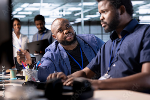 Unhappy manager admonishing technician after failing to properly reconfigure server farm to optimize it for data processing requirements of customers, berating him while pointing to coding mistakes photo