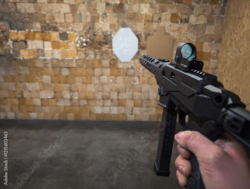 Shooting from a modern 9mm caliber carbine with a holographic sight at a shooting range. Photo from a first-person view.