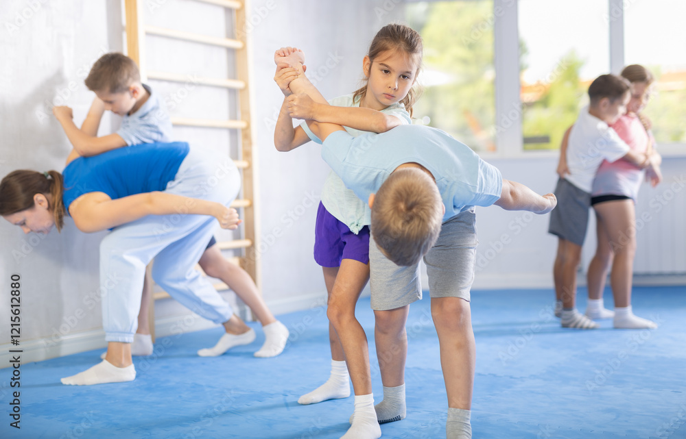 In training hall, children are working on arm twists, learning to control and subdue opponents. In training hall, children are working on arm twists, learning to control and subdue opponents.