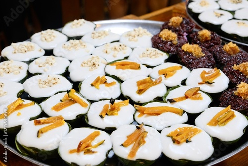 
Khanom Tako at Khlong Lat Mayom, a floating market in Taling Chan, Bangkok, Thailand: a Thai dessert made from glutinous rice flour and coconut cream, served in a pandan leaf or banana leaf casing photo