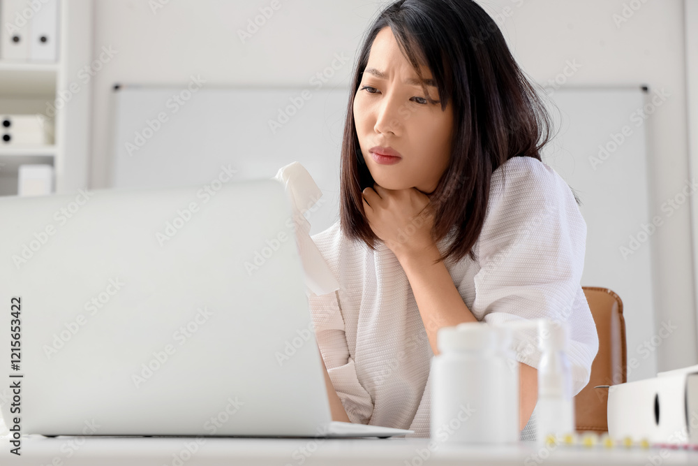 Ill Asian businesswoman with tissue in office Ill Asian businesswoman with tissue in office