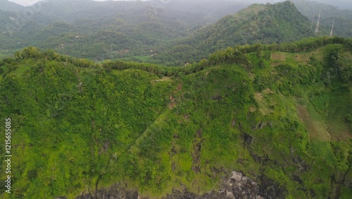 Drone view of hills with trees and agricultural fields with footpaths on the Silayur hills, Kebumen photo