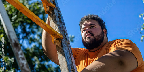 Man Ascending Wooden Ladder Outdoors photo