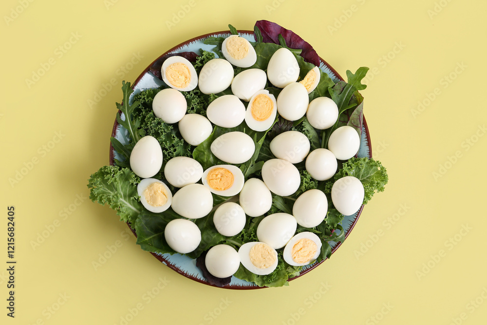 Plate with fresh boiled quail eggs, lettuce and arugula on yellow background Plate with fresh boiled quail eggs, lettuce and arugula on yellow background