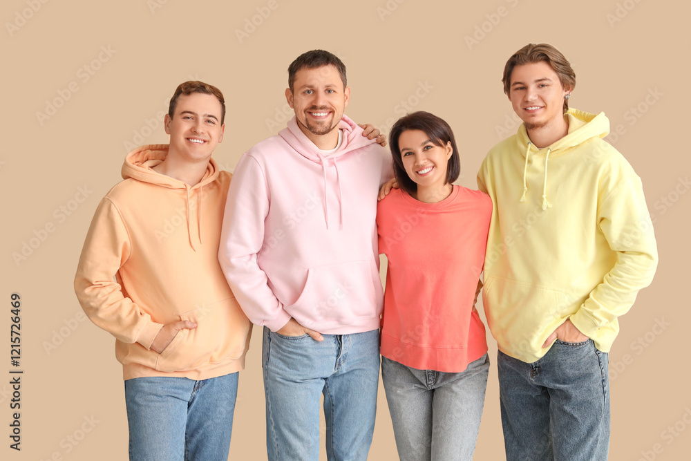 Group of young people hugging on beige background Group of young people hugging on beige background