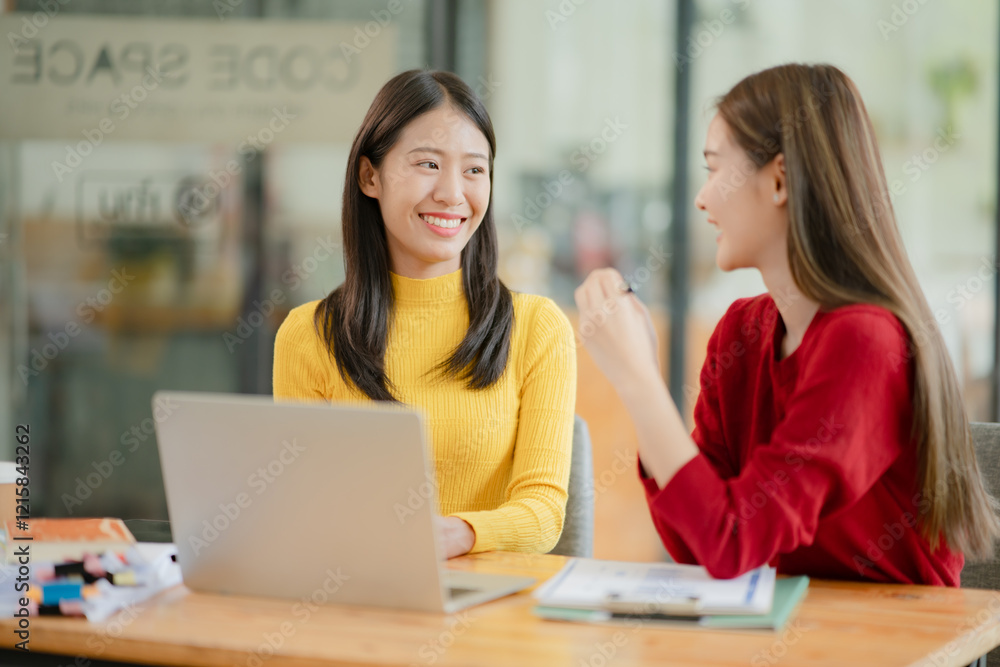 Two Asian business women discuss and discuss company paperwork. in the office room Two Asian business women discuss and discuss company paperwork. in the office room