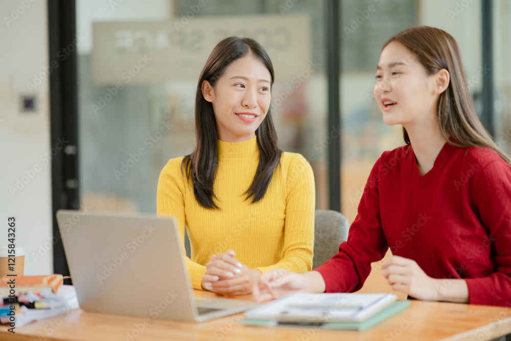 Two Asian business women discuss and discuss company paperwork. in the office room Two Asian business women discuss and discuss company paperwork. in the office room