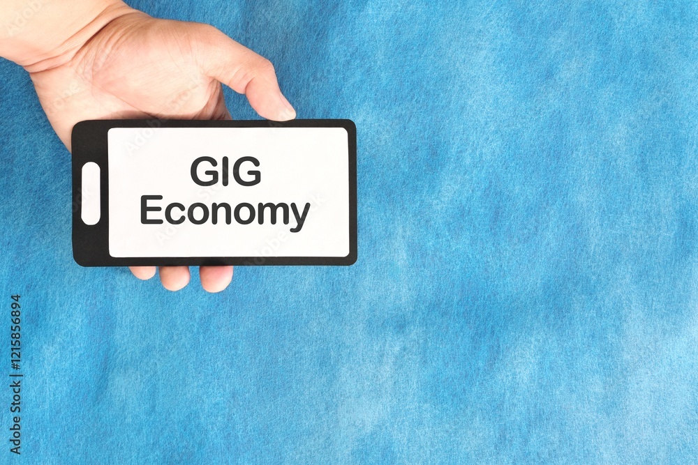Human hand holding mobile phone with written phrase gig economy. Gig economy concept.
