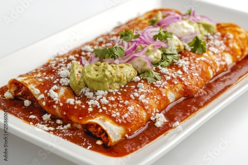 Delicious enchiladas topped with cheese, sour cream, guacamole, and onions. photo