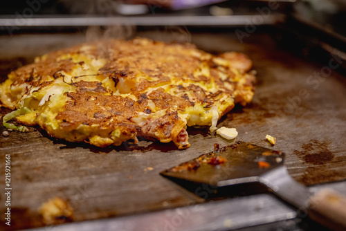 Okonomiyaki is one of Osaka’s famous foods.Teppanyaki is a Japanese cuisine that uses an iron griddle to cook food. photo