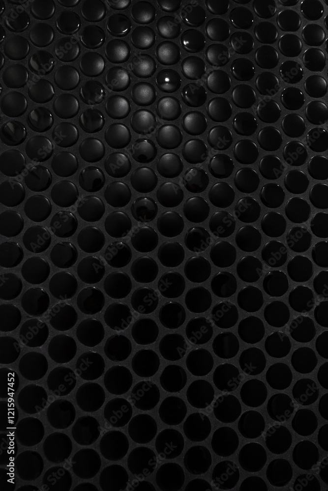 Close-up view of a surface composed of small, round, black tiles arranged in a repeating pattern. The tiles have a glossy finish, creating a smooth and uniform texture. Close-up view of a surface composed of small, round, black tiles arranged in a repeating pattern. The tiles have a glossy finish, creating a smooth and uniform texture.