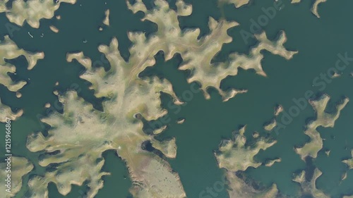 Aerial drone shot of Karamchat Dam, with sunlight glimmering on the calm surface of the water. photo