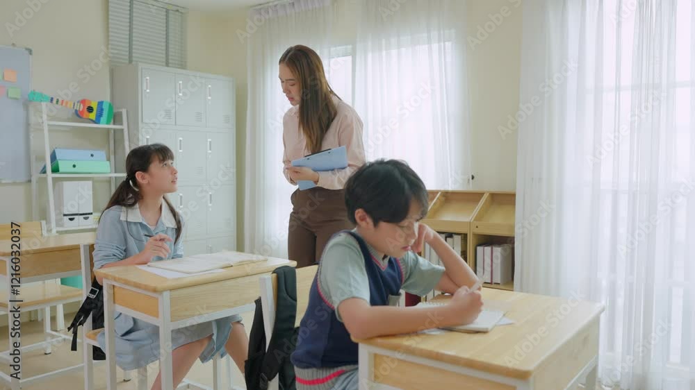 Asian female teacher educating group of students at elementary school. Asian female teacher educating group of students at elementary school.