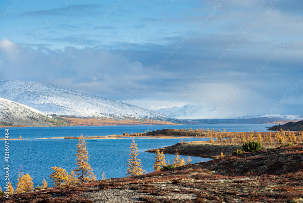 Russia. Magadan Region. Beautiful Lake Momontay against the backdrop of a snowy mountain range. Late autumn in the vicinity of Lake Momontay.. Russia. Magadan Region. Beautiful Lake Momontay against the backdrop of a snowy mountain range. Late autumn in the vicinity of Lake Momontay..