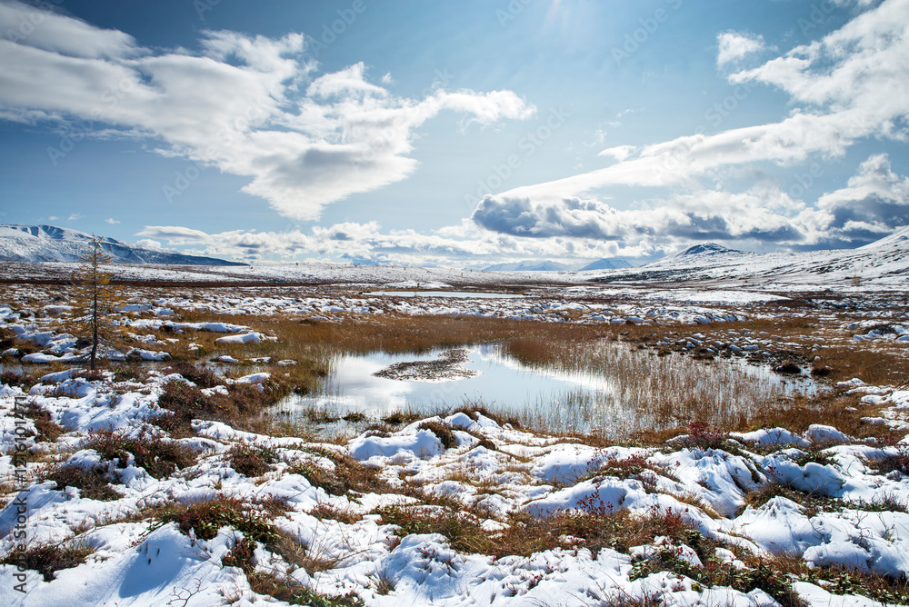 Russia. Magadan Region. Beautiful Lake Momontay against the backdrop of a snowy mountain range. Late autumn in the vicinity of Lake Momontay. Russia. Magadan Region. Beautiful Lake Momontay against the backdrop of a snowy mountain range. Late autumn in the vicinity of Lake Momontay.