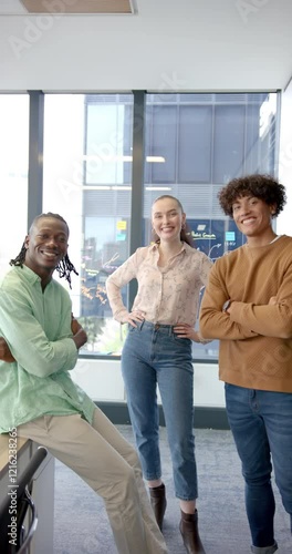 Vertical video: Standing together in modern office, smiling colleagues posing confidently