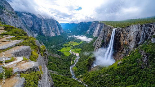 Breathtaking waterfall cascading into misty valley surrounded by mountains