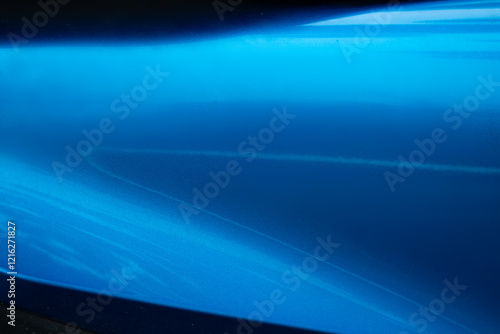 A blue car with a blue paint job. The paint job is very smooth and shiny. The car is parked in a parking lot