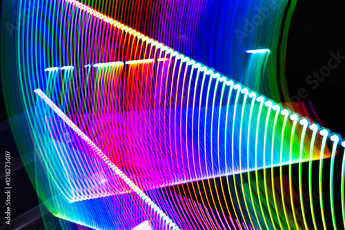 A colorful, abstract image with a rainbow of colors. The image is a representation of light and movement, with the colors blending and swirling together. Scene is one of energy and excitement