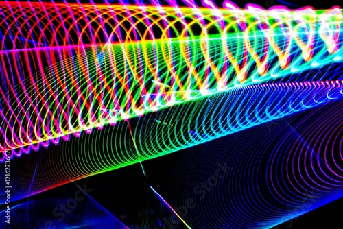 A colorful, swirling pattern of light and dark colors. The colors are bright and vibrant, creating a sense of energy and movement. The image is abstract and dynamic, with the colors blending
